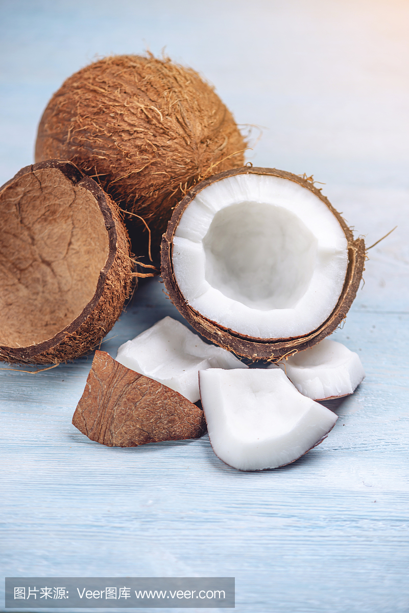 打開椰子與白色果肉在藍色木制背景。有機健康膳食產品廣泛應用于化妝品